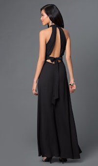the back view of a woman wearing a black maxi dress